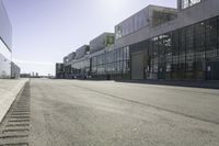 an empty industrial building with windows in the middle of it and an empty parking lot to the side