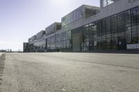 an empty industrial building with windows in the middle of it and an empty parking lot to the side