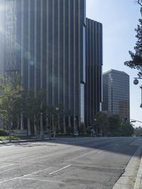 a person walking down a deserted city street with skyscrapers in the background in the daytime