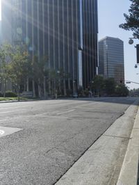 a person walking down a deserted city street with skyscrapers in the background in the daytime