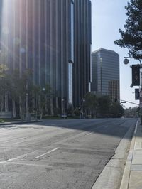 a person walking down a deserted city street with skyscrapers in the background in the daytime