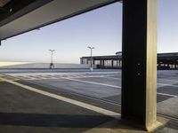 the sky is seen through a window of an airport parking garage where people can walk on the runway and check the plane