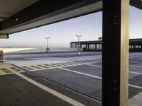 the sky is seen through a window of an airport parking garage where people can walk on the runway and check the plane