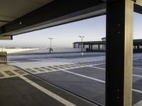 the sky is seen through a window of an airport parking garage where people can walk on the runway and check the plane