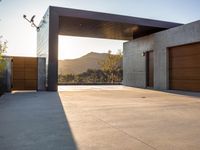 the sun shines over a garage door in a building near some mountains of green