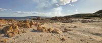 a rocky beach under clouds on a sunny day in spain stock photo, images and stock photos