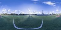 the view from the perspective point of a soccer field, in the afternoon with blue sky and white clouds