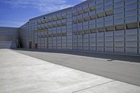 an airplane is sitting on the tarmac at a hangar as people watch from it