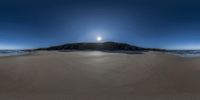 an island sits on the sand at the bottom of a beach as a sunny and clear blue sky hangs above it