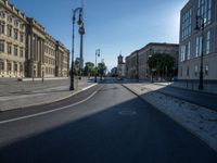 a street light next to an empty road in front of a building with a traffic light on top of it