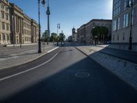 a street light next to an empty road in front of a building with a traffic light on top of it