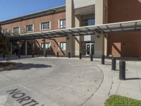 the entrance to an elementary building with trees and bushes on either side of the walkway