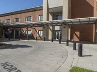 the entrance to an elementary building with trees and bushes on either side of the walkway