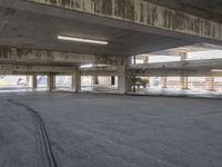 an empty parking garage with no cars on the side walk of it, with light at top