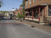 a view down the street in a city during a sunny day, showing buildings and a clock tower