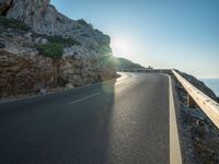 a road leading to a rocky outcropping with some trees in the distance