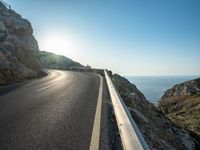 a road leading to a rocky outcropping with some trees in the distance