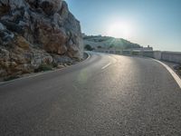 a road leading to a rocky outcropping with some trees in the distance