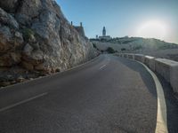 a road leading to a rocky outcropping with some trees in the distance