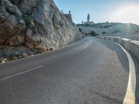 a road leading to a rocky outcropping with some trees in the distance