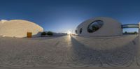 a 360 degree image of a courtyard in the sun with a small building and a big window