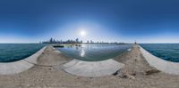 a 360 view of a beach with an area that is completely empty and the sun shines brightly over the water