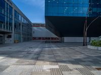 a white building next to a pool in a courtyard area with a walkway leading into it