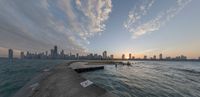 the sunset is about to light up over the city skyline of chicago, illinois from a pier that overlooks lake michigan