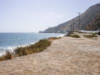 the view of the beach and the shoreline from one side of it on a sunny day