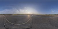 the sun shining down on a cloudless sky above an airport tarmac with some yellow cars