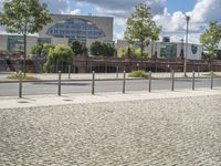 a fenced off street with some buildings behind it on a sunny day in the city