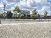 a fenced off street with some buildings behind it on a sunny day in the city