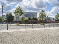 a fenced off street with some buildings behind it on a sunny day in the city