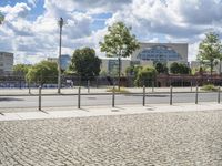 a fenced off street with some buildings behind it on a sunny day in the city