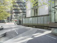 concrete benches in front of glass doors on a sidewalk on a sunny day in the city