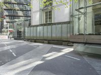 concrete benches in front of glass doors on a sidewalk on a sunny day in the city