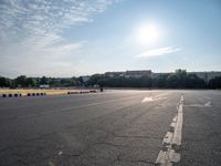 a man riding a skateboard down an empty parking lot in front of a building