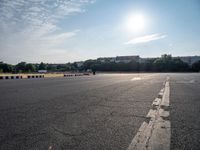 a man riding a skateboard down an empty parking lot in front of a building