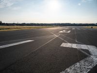 a view of a runway on an airfield with two white arrows pointing right and left