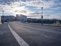 a street intersection with buildings in the background and a road marking on the pavement for pedestrians