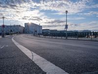 a street intersection with buildings in the background and a road marking on the pavement for pedestrians