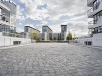 there is an empty courtyard on a sunny day with cloudy skies in the background in this area