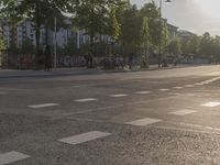 a bike and pedestrian cross walk in the middle of an empty street with several bikes parked on both sides