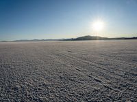 a sun shines brightly over a vast expanse on a sunny day in winter attire