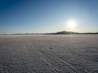 a sun shines brightly over a vast expanse on a sunny day in winter attire