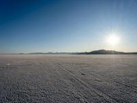 a sun shines brightly over a vast expanse on a sunny day in winter attire