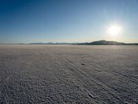 a sun shines brightly over a vast expanse on a sunny day in winter attire