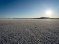 a sun shines brightly over a vast expanse on a sunny day in winter attire