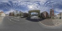 this is an 360 lens view of the street in front of some houses on a sunny day