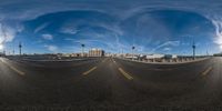 a panorama camera photograph of a bridge on a sunny day with a big cloud sky